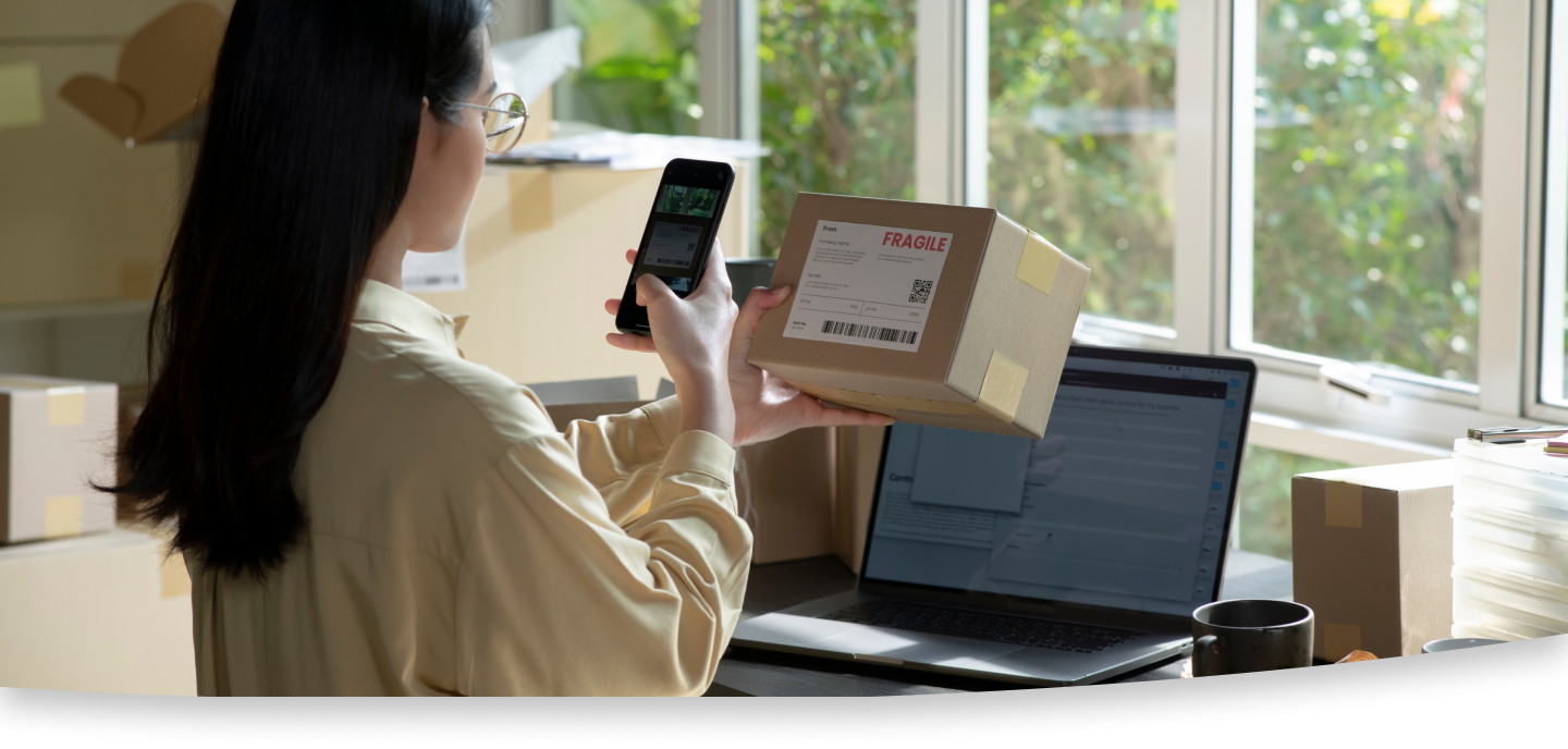 Female scanning a label on a package with her smart phone